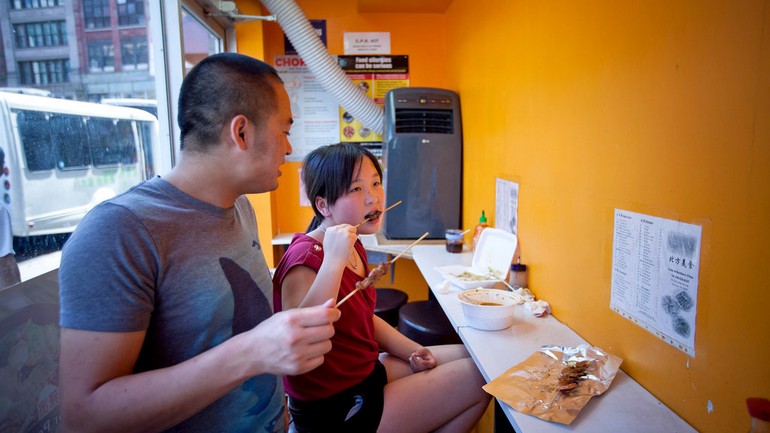 店里只有几张凳子。There are only a few stools along an orange wall..jpg