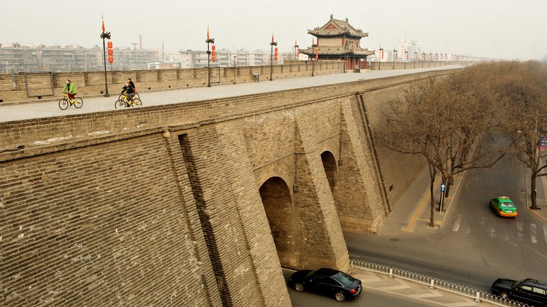 游客在西安城墙上骑车。Cyclists ride along a stretch of the city walls in Xian, China..jpg