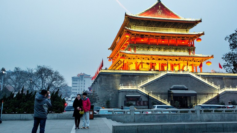 两个人在西安14世纪的鼓楼前留影。Two people pose for a picture in front of Xian's 14th-century Drum Tower..jpg