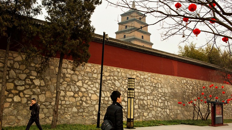 行人经过大雁塔。Pedestrians walk past the Big Wild Goose Pagoda, a Buddhist temple..jpg