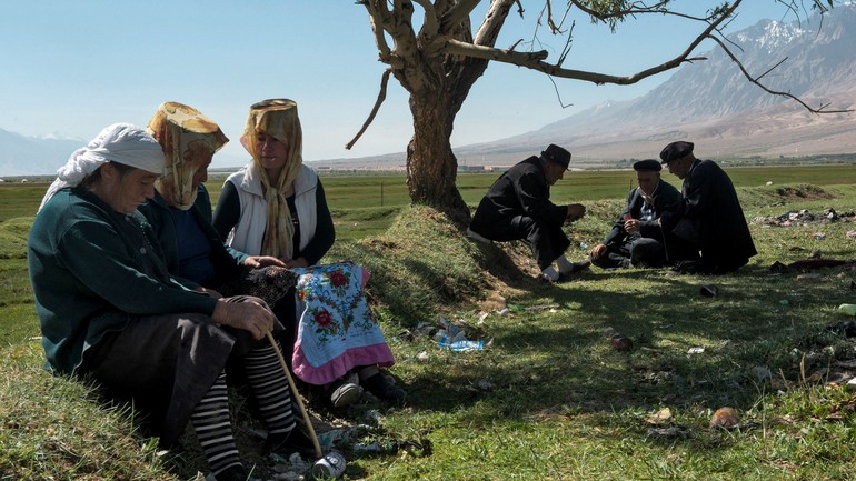 塔吉克族人在草地上打牌聊天。In the grassland, Tajik men playing cards while women chat..jpg