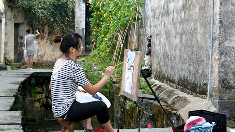 An art student from nearby Hefei paints a narrow lane lined with Ming Dynasty-era homes in Xidi..jpg